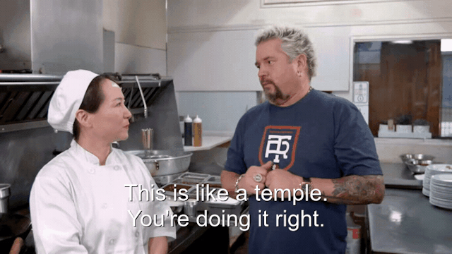 90% sure it's Guy Fieri cooking in a kitchen preparing food. Caption: This is like a temple. You're doing it right.