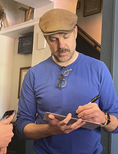 Jason signing autographs on the set of Ted Lasso.