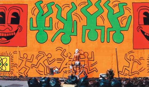 twixnmix:Keith Haring painting a mural on Houston Street and Bowery in New York City, 1982.  (Photos