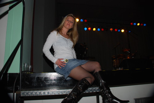 Sexy lady posing in denim skirt, black pantyhose and boots. Woman in pantyhose