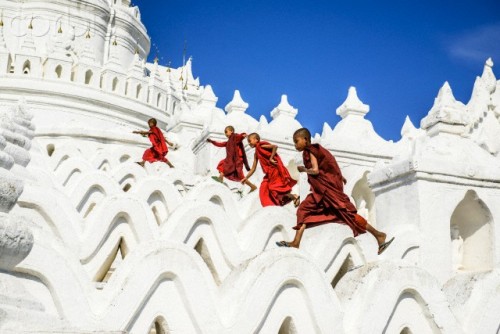 Asian monks running on white temple walls, Hsinbyume Pagoda, Mandalay, Sagaing, Myanmar (Spaces Imag