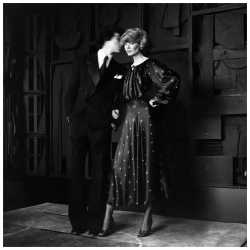 eyeofthevoid:  Model Charly Stember, standing with a man before a Louise Nevelson sculpture, and wearing an ankle-length, black silk satin print dress with bloused bodice by John Anthony 1974. Photo by Francesco Scavullo. 