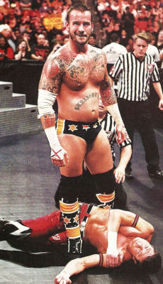 CM Punk standing over a broken lil Evan Bourne.