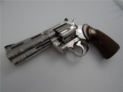 gunrunnerhell:  Colt PythonA heavily but masterfully engraved Colt Python, one of the famed revolvers from Colt’s snake series. Chambered in .357 Magnum, there are several variations of the Python, each with varying degree of collector status and price.