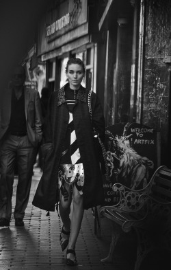 books0977:  Rooney Mara with architecture for Interview Magazine, November 2015. Photograph by Peter Lindbergh. “Coat: Coach. Dress and earring (worn on bag): Miu Miu. Shirt: Sonia by Sonia Rykiel. Sweater, bag, and shoes: Prada.” 