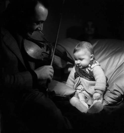 Django Reinhardt joue du violon à son fils Babik âgé de huit mois, Paris, 1945 - Emile Savitry. Nudes &amp; Noises  