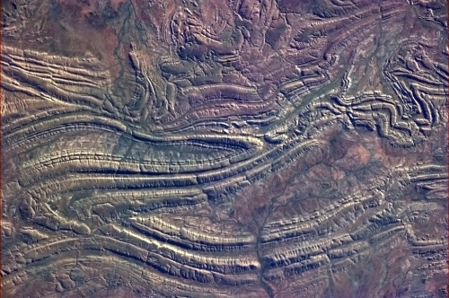 colchrishadfield:The early dawn light turns these Outback rock folds into petroglyphs, as if there&r