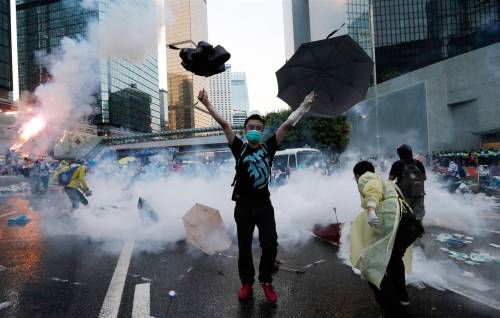 politics-war:A protester raises his umbrellas near tear gas in Hong Kong. 