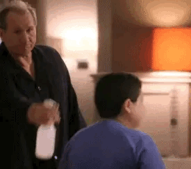 jay from modern family spraying manny with a spray bottle