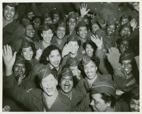 Home Again A crowd of African American Women’s Army Corps members waving at the camera, Staten