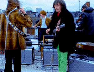 John Lennon And George Harrison Sharing A Cigarette During The Beatles’ Final Live Performance, 1969