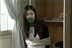 sittightbondage:  A favorite video of mine. A very attractive Korean girl in some black skinny jeans is terrorized by a burglar.  I love the way she squirms on what appears to be a stool. Also the Asians love to use green tape. 