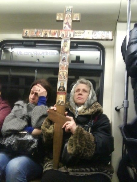 woman holding cross in subway train