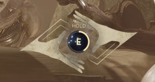 Screenshot of a zoomed in UI element in Warframe. It's a pair of hands surrounding an E button with the command "HOLD".