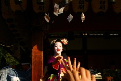 geisha-kai:  Maiko Tomitae throwing lucky beans off the stage of the Yasaka Shrine by goutenphoto on GanrefYou can catch yours during the Setsubun!