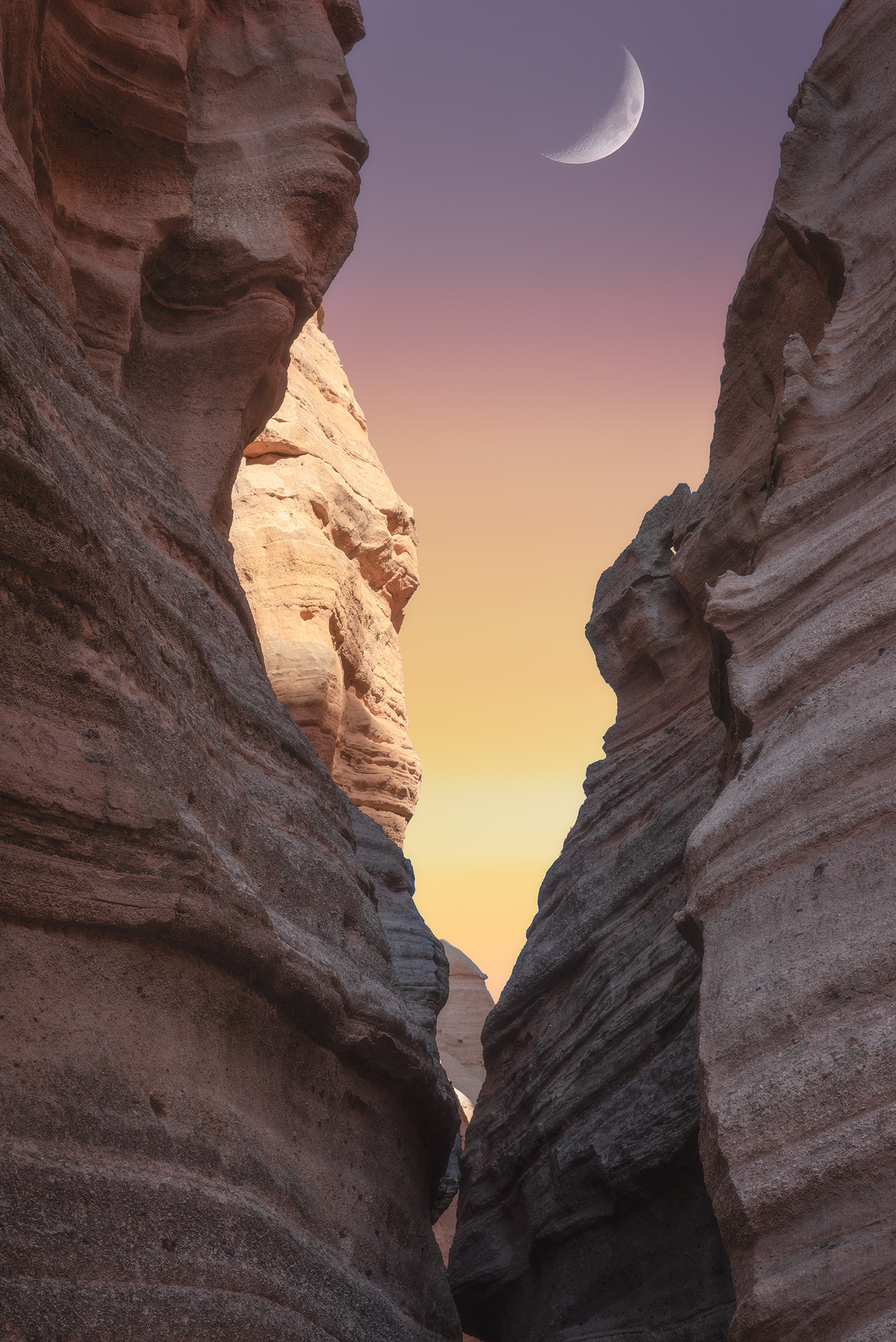 amazinglybeautifulphotography:The crescent moon in between some canyons in Tent Rocks,