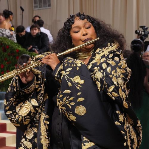 Judge the Jewels: Lizzo Embodies Gilded Glamour with Lush Lorraine West Necklaces and a Gold Flute. 