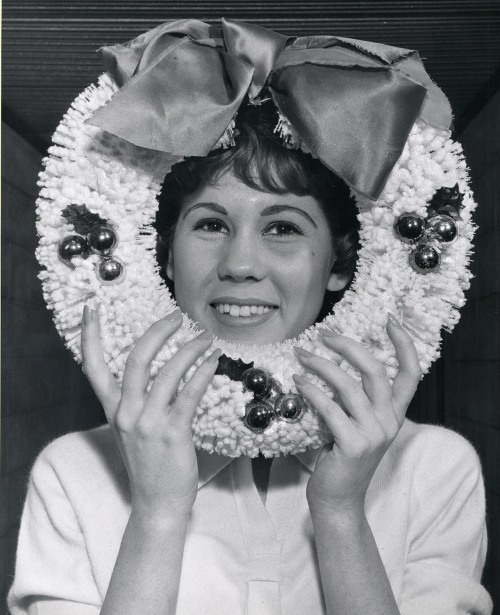 A woman with her face framed in a Christmas wreath, University of Wisconsin - Madison, Wisconsin, 19