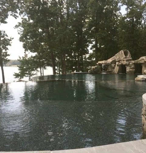 Hot Tub - Huge Rustic Backyard Stone And Custom-shaped Infinity Hot Tub Idea