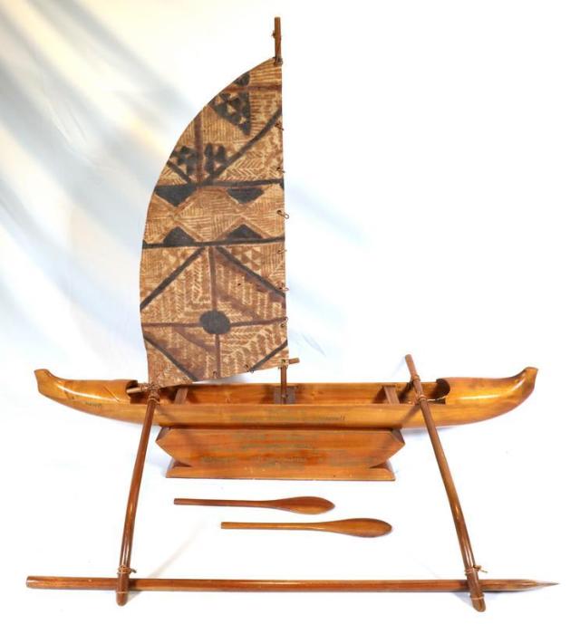 A model of an outrigger canoe carved from highly polished brown wood. The canoe has a tall mast and a brown and black fiber sail of Fijian design. The name of the ship is found on one side of the stern: HAWAII. The model includes two paddles and three pieces for outrigging, made of wood and attached with rope. The hull rests on a stand made from the same material as the boat. When the canoe is in place on the stand, a full inscription (partly on both pieces) reads: Presented to / President Franklin D. Roosevelt / From Troop 13 B.S.A. Honolulu.