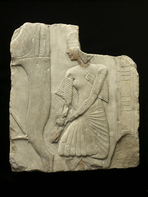 Fragment of an ancient Egyptian tomb relief (limestone with traces of paint), depicting a scribe of 