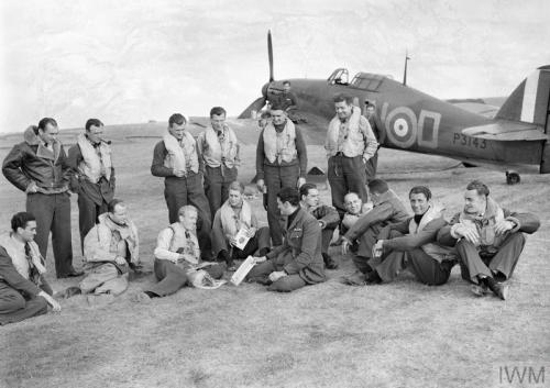 Pilots of &lsquo;B&rsquo; Flight, No. 32 Squadron, relax on the grass at RAFHawkinge in front of a H