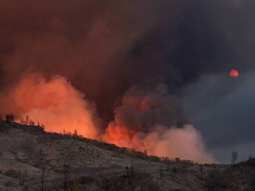 fotojournalismus:Fire blazes as smoke tints the view of the moon rising over the Rocky Fire near Low