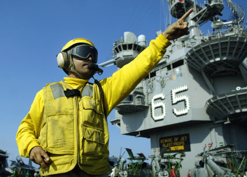 US Navy (USN) CHIEF Aviation Boatswain’s Mate (CABM) Jimmy Candelaria, directs aircraft on the