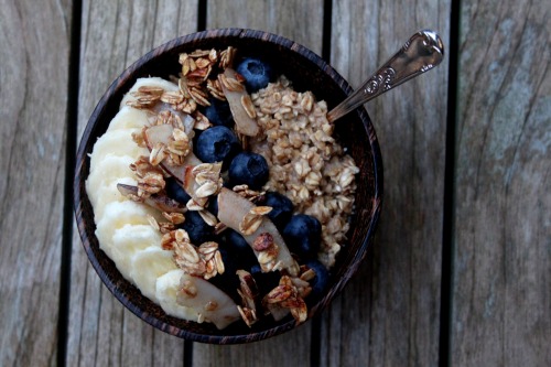 cinnamon oatmeal topped with banana slices, fresh blueberries and maple coconut granola. pure perfec
