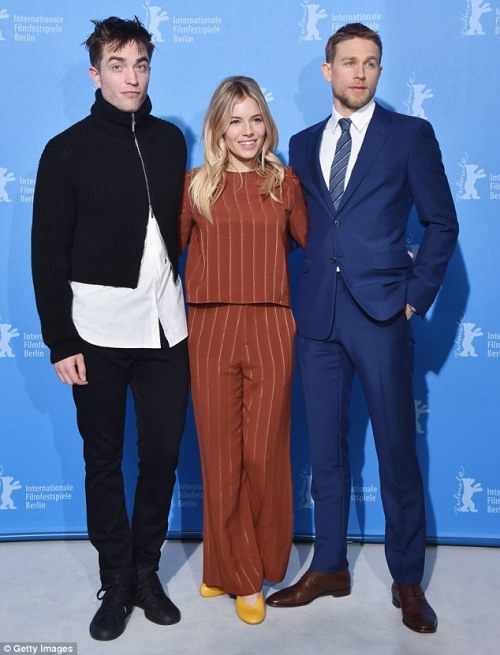 Sienna Miller, rocking a matching pinstriped set like only she can, with Robert Pattinson and Charli