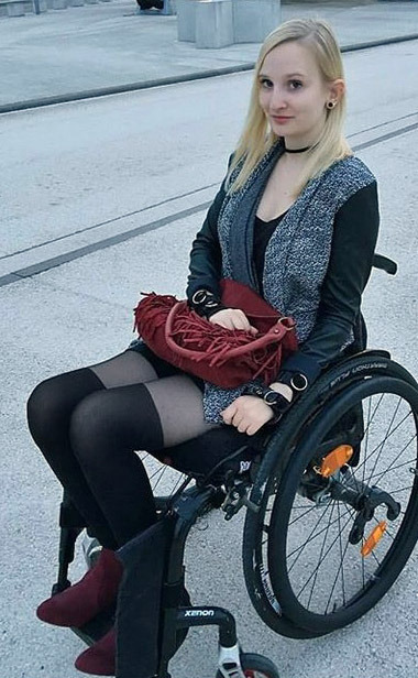 Beautiful blond para in wheelchair with atrophied legs in tights