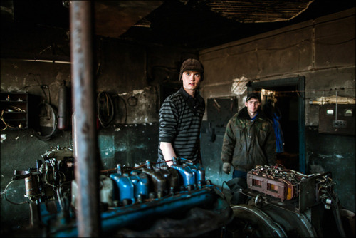 Chief of crew Sasha maintains engines at meteorological station Sannikova, Kotelniy Island, Yakutia,