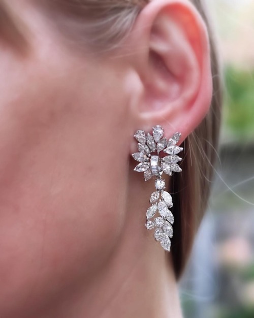 This pair of platinum ear pendants designed as floral and foliate clusters set with round, marquise 