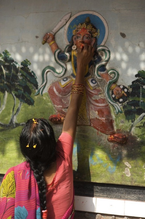 Woman worshipping deities at nepali temple.