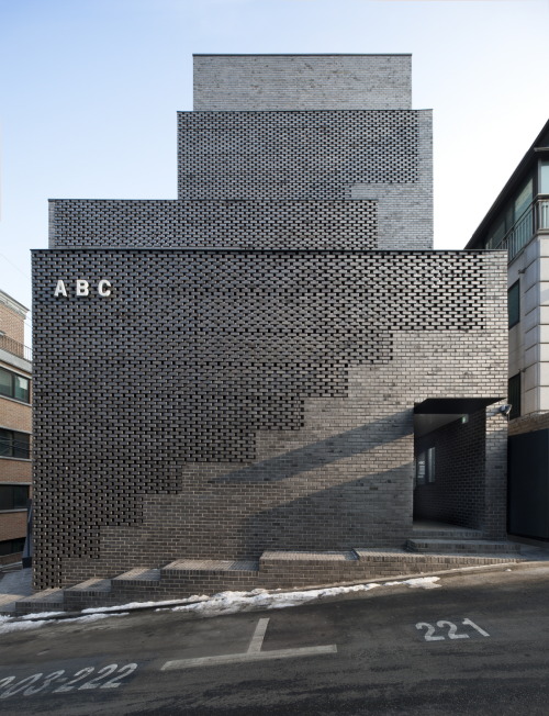 dezeen:  Perforated brick walls front this Seoul office block by Wise Architecture, flanking staircases that lead up to a rooftop terrace with views of a nearby historic park »