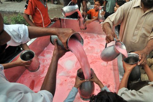 Pakistani volunteers distribute sweet drinks in Lahore on July 11, 2013.[Credit : Arif Ali/AFP/Getty