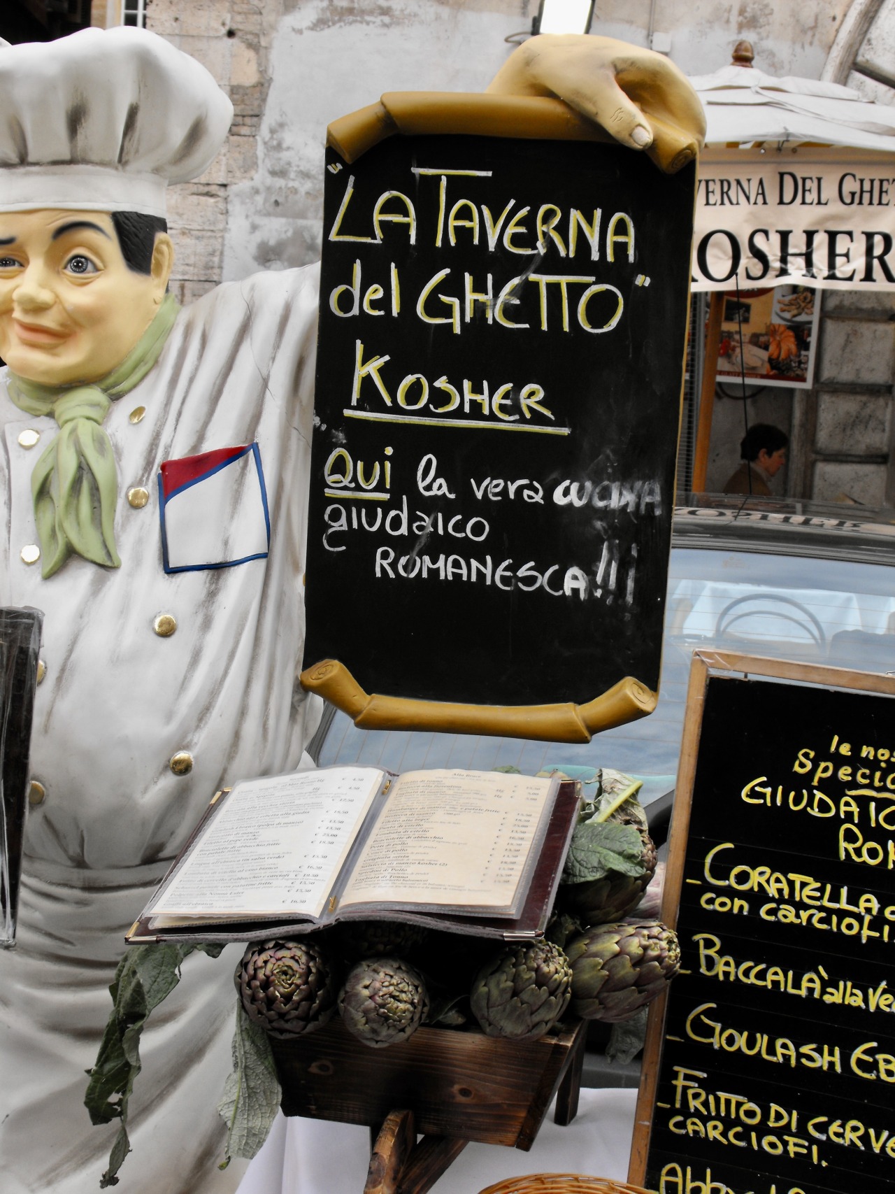 La Taverna del Ghetto, ristorante, Roma, 2009. . The promotion in front of the restaurant includes artichokes, the base for perhaps the most famous Roman Jewish delicacy Carciofi alla Giudia. Recently the dish was declared non-kosher by a rabbinical board in Jerusalem. A traditional dish, and a delicious one, in the kosher restaurants of Rome, that decision was treated with umbrage by Rome’s Jewish population and with dismay by many other Romans who consider Carciofi alla Giudia a major winter delicacy and a star in the culinary firmament of a city known for its fine cuisine. #food#restaurants#advertising#artichokes #carciofi alla giudia #roma#lazio#italia#2009 #photographers on tumblr