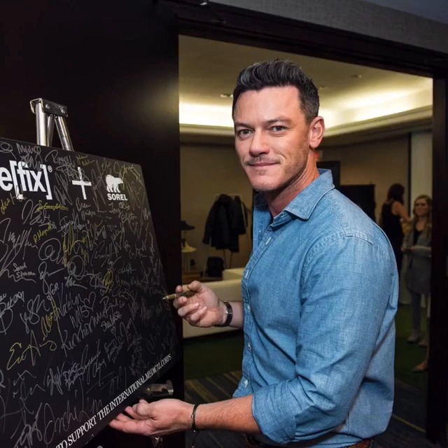 Luke Evans signing a charity board last year at TIFF 2017. - (x)