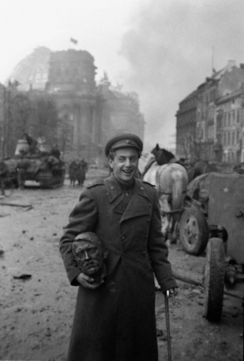 historicaltimes:A Soviet soldier with the head of a statue of Hitler, Berlin, 1945 via reddit