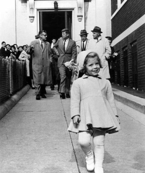 historicaltimes:Caroline Kennedy walks ahead of the most powerful man in the world who carries her l