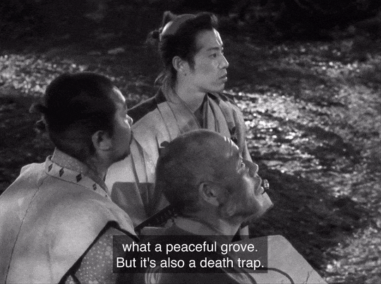 Three characters from Seven Samurai survey an area while one says, "What a peaceful grove. But it's also a death trap."