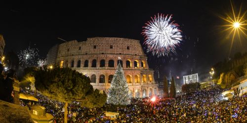 People cheer in front of Rome&rsquo;s ancient Colosseum as fireworks explode to celebrate the new ye