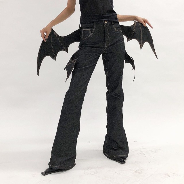 model spreading denim bat wings stitched into black jeans