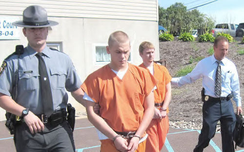 mus1g4: Inmates accursed of burglary being led to court.  Matching uniforms and restraint belts