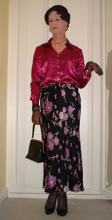 A lovely silky mauve blouse with black floral patterned skirt and patent stiletto and handbag.