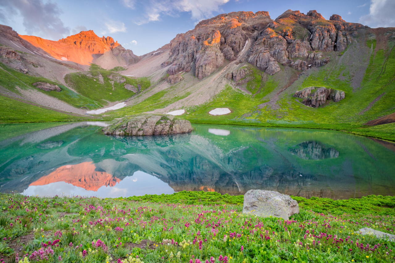 softwaring:  Early morning light over a field of wildflowers and crystal blue lake