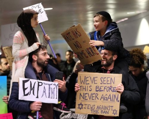 A young Muslim girl and her father, and a young Jewish boy and his father, protesting the immigratio