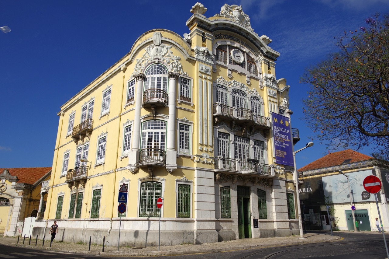 José Dominguos Barreiros, 2022@ Poço do Bispo, Bairro Braço de Prata, Lisboa, Portugal #old#building#revisitinglisbon#lisboa#portugal#braçodeprata#square#clock#town#historical#yellow#blue#windows#green#door