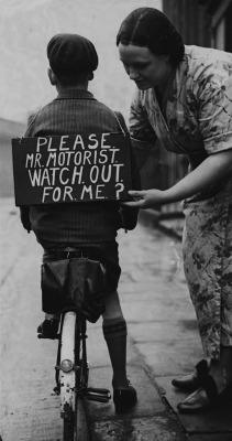 luzfosca:  A mother fastening a notice reading ‘Please Mr Motorist, watch out for me’, onto her son’s back before he sets out on a trial bicycle ride, 1937. From Hulton Archive/Getty Images 