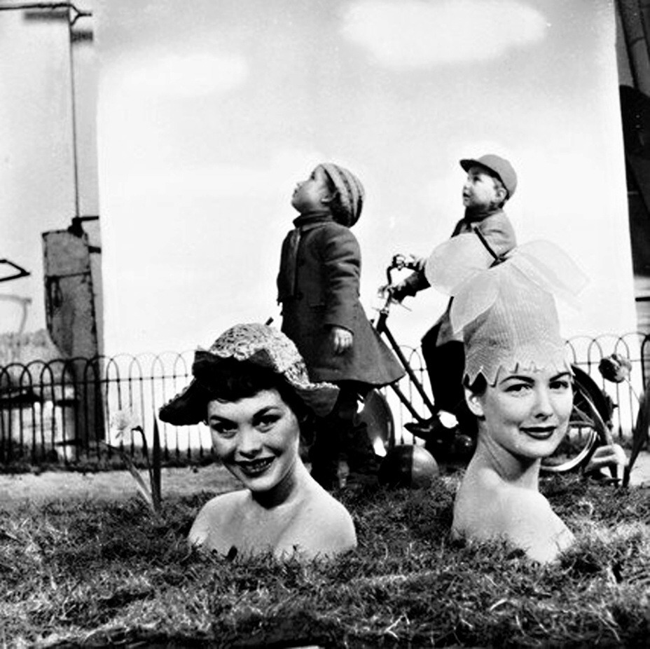 Zoltan Glass - Models wearing hats in the shape of flowers. 